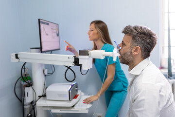 Man performing pulmonary function test and spirometry using spirometer at medical clinic. Spirometry of lungs © Graphicroyalty