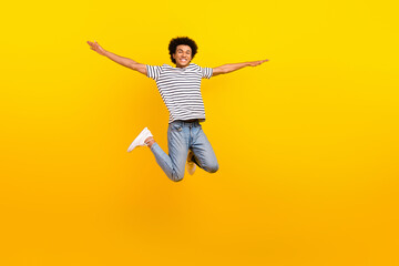Obraz na płótnie Canvas Full body size photo of young jumping handsome guy arms wings flight active time spending have fun isolated on yellow color background