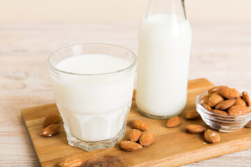 Top view of the almond milk in the glass bottle with almond nuts on the colored table. top view vith copy space