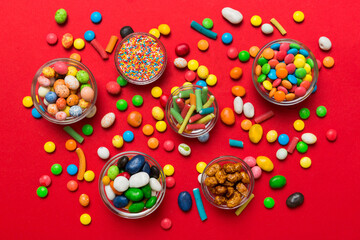 different colored round candy in bowl and jars. Top view of large variety sweets and candies with copy space