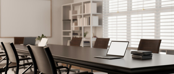 A laptop mockup on a meeting table in modern minimal meeting room.