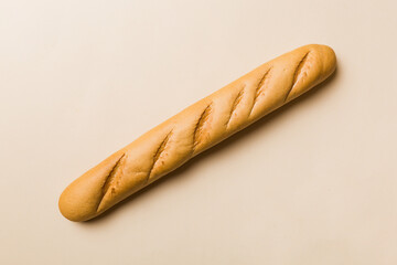 Minimalist french baguette on colored background. fresh bread as background, top view with space...