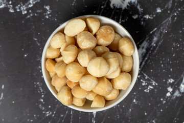 Macadamia nuts. Peeled Macadamia Nuts in a ceramic bowl. superfood. Vegetarian food concept. healthy snacks. Top view
