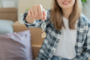 Moving house, relocation. Woman hold key house keychain in new house. move in new home. Buy or rent real estate. flat tenancy, leasehold property, new landlord, dwelling, loan, mortgage.