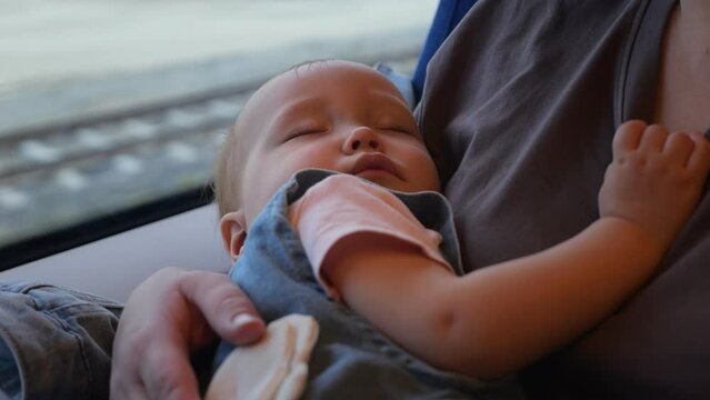 Toddler girl falls asleep during journey with mother on fast train. Daughter feels tired and exhausted during train ride with adult parent