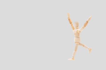Photograph of a wooden mannequin with light gray coloured background. Photo to be able to crop. Concepts. Selective focus. Space for copy