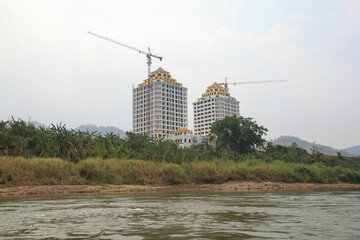 Massive out-of-place ongoing construction next to the Laotian border entry post by the Thai-Lao Friendship Bridge IV, seen from the Mekong River, Laos.