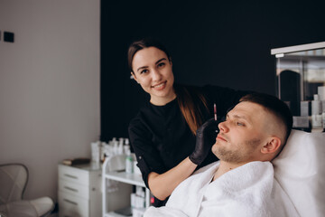 Female Beautician Giving Male Patient Botox Injection In A Forehead.