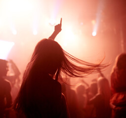 Dancing, club and back of woman at a concert, disco event or psychedelic trance festival. Night,...