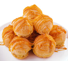 Tasty round eclairs with cream on white background