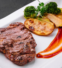 Steak with baked potatoes on plate