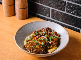 Traditional german braised veal cheeks in brown sauce with mashed potatoes