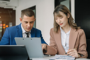 Obraz premium Business documents on office table with smart phone, tablet and laptop computer and graph with social network diagram and two colleagues discussing data in office.