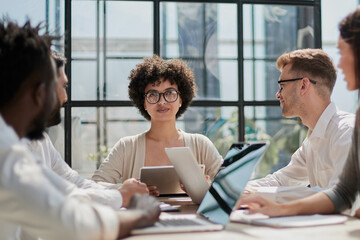 Fototapeta premium Employees working at computer together, discussing content