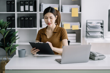 Business woman working at office with laptop and documents on his desk, financial adviser analyzing data.