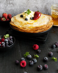 
Fresh pancakes with berries. Breakfast. On a dark background