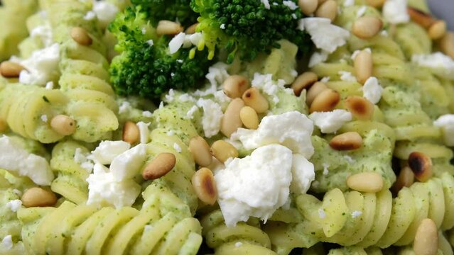 Creamy broccoli feta pasta with pine nuts. Healthy food. Rotating video