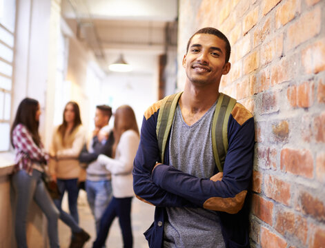 University, education and portrait of man with crossed arms ready for college, class and learning. Scholarship, happy and face of male student in hallway with friends for school, academy and campus