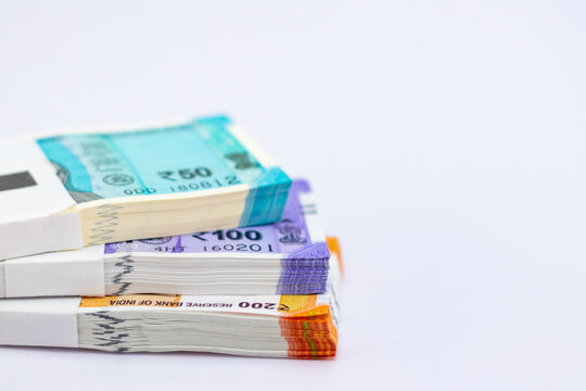 High angle close up shot of new fifty, one and two hundred rupee notes on white background, showing finance concept.