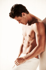 Obraz premium Sexy, body and shirtless man in a towel while thinking, handsome and clean. Strong, fitness and young male model posing topless with water drops, beauty and motivation or inspiration after shower