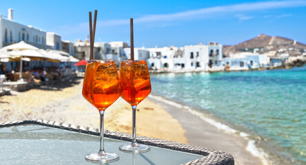 two aperol spritz on a summer evening in a mediterranean restaurant - obrazy, fototapety, plakaty