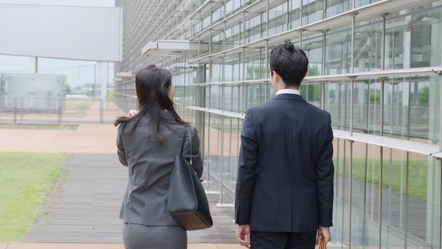 通勤しながら話すビジネスマン男女