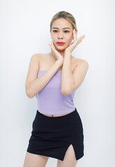 Portrait isolated cutout studio shot of Asian beautiful pretty cheerful female model in tube cropped top shirt standing smiling using hands massaging cream oil moisturizer on face on white background