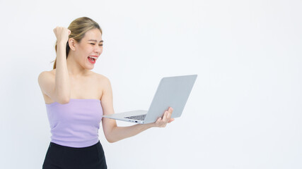 Isolated cutout studio shot of Asian excited surprised happy cheerful female model standing smiling looking at laptop computer winning lottery achievement victory goal deal done on white background