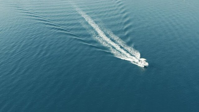 Speed boat cruising in blue Aegean sea, Greece, Aerial drone video, footage 4k. Wake on calm sea 