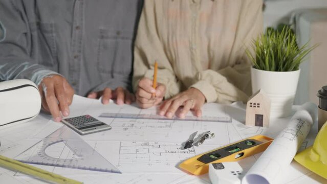 Architect team meeting consult and work for architectural construction project working with partner and engineering they editing and drawing on blueprint paper plans