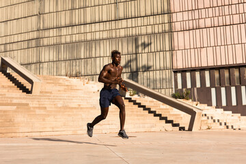 Fitness training outdoors. Handsome African man doing exercises outside. Muscular man training.