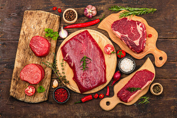 Set of various steaks with spices. Cuts includes ribeye, eye round, flank and striploin steaks