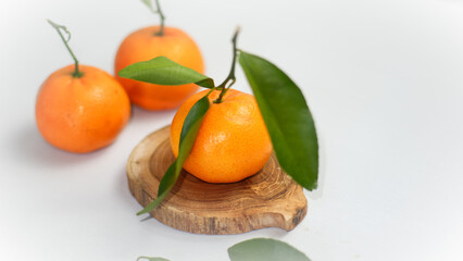 ripe orange fruit with green leaf on wooden coaster