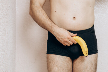 a guy without clothes holds a missing banana in his hand. Erection problem, male health