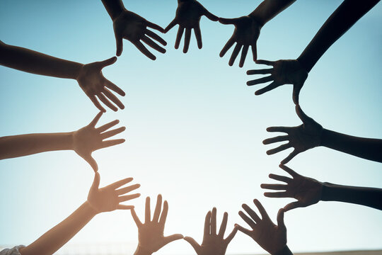Group, circle and open hands for support and teamwork for trust in the community with sky background. Together, diversity and hand for motivation and solidarity for global collaboration and unity.