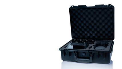 Drone and accessories in plastic case isolated on white background. UAV or unmanned aerial vehicle and drone accessories in protective travel case. LiPo rechargeable battery in storage container.