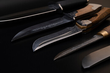 Damascus steel knives on a black background. Kitchen knives. background with japanese knife. A set...