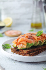 A rye bread sandwich with avocado and salmon