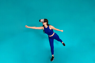 Woman jumping while wearing vr glasses.
