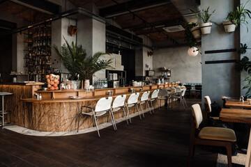 Modern interior in cafe with bar and chairs with concrete walls and wooden floor indoors - obrazy, fototapety, plakaty