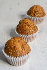 Three muffins placed on a table.