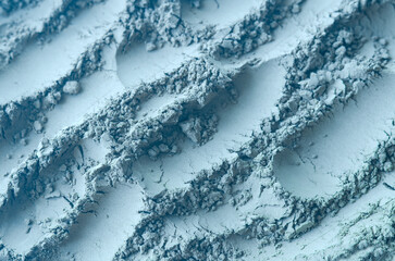 Light blue (gray) bentonite facial clay powder (alginate modeling mask, eye shadow, body wrap) texture close up, selective focus. Abstract background with brush strokes. - obrazy, fototapety, plakaty