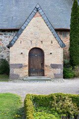 Fototapeta na wymiar Entrance of the village church of Steinbergkirche in Schleswig-Holstein, Germany