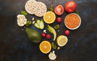 Heart shaped composition of healthy FODMAP, Paleo, Mediterranean diet food. Organic fruits, vegetables, greenery, lentil and gluten free diet cakes