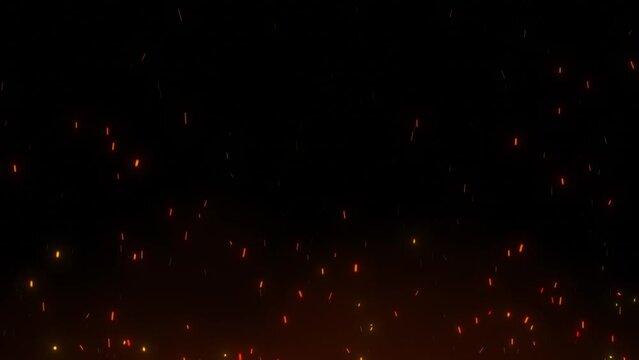 Flying coals from the fire. Close-up of red-hot sparks of a fire flying upwards. Fire particles on a black background.