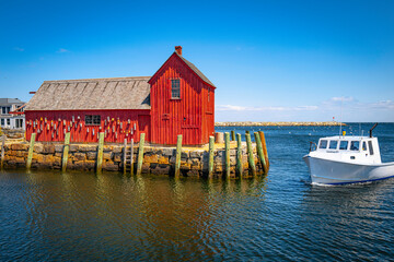 Red fishing shack and a trawler entering in Rockport Harbor, Cape Anne, Massachusetts