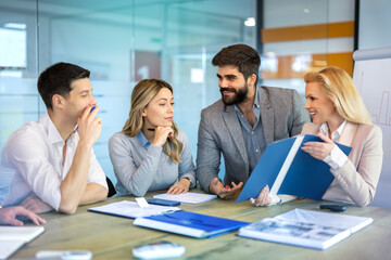 Group of multi-ethnic lawyers examining documents to determine if they are relevant, responsive, or privileged at meeting in modern office.