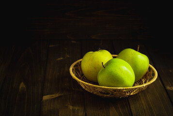 Green organic healthy apples in bowl on wooden board. Healthy food