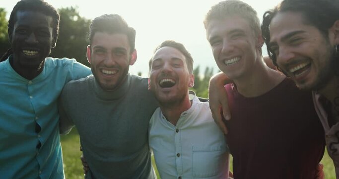 Happy male friends having fun together outdoor - Group of young men hugging each other at park while smiling on camera - Powered by Adobe
