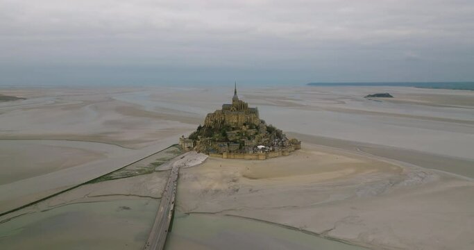 Fly over Mont Saint-Michel, one of Europe's most unforgettable sights. Located in the bay where Normandy and Brittany merge, the island attracts the attention of tourists from all over the world